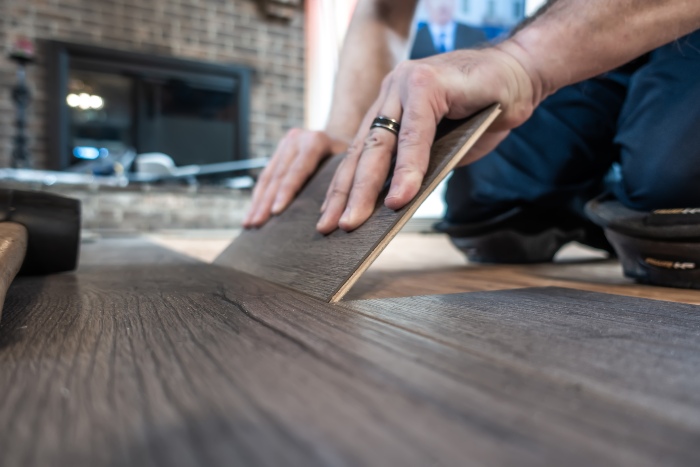 Installing dark wood laminate flooring.