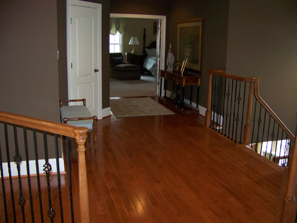 Hardwood floor hallway with staircase.