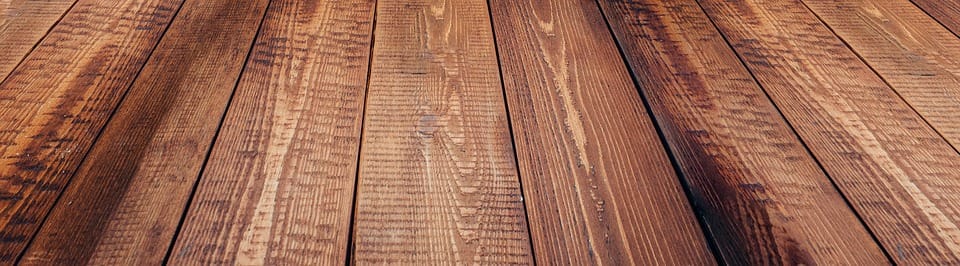 Here's an alt tag for the image: Dark brown wood plank floor.