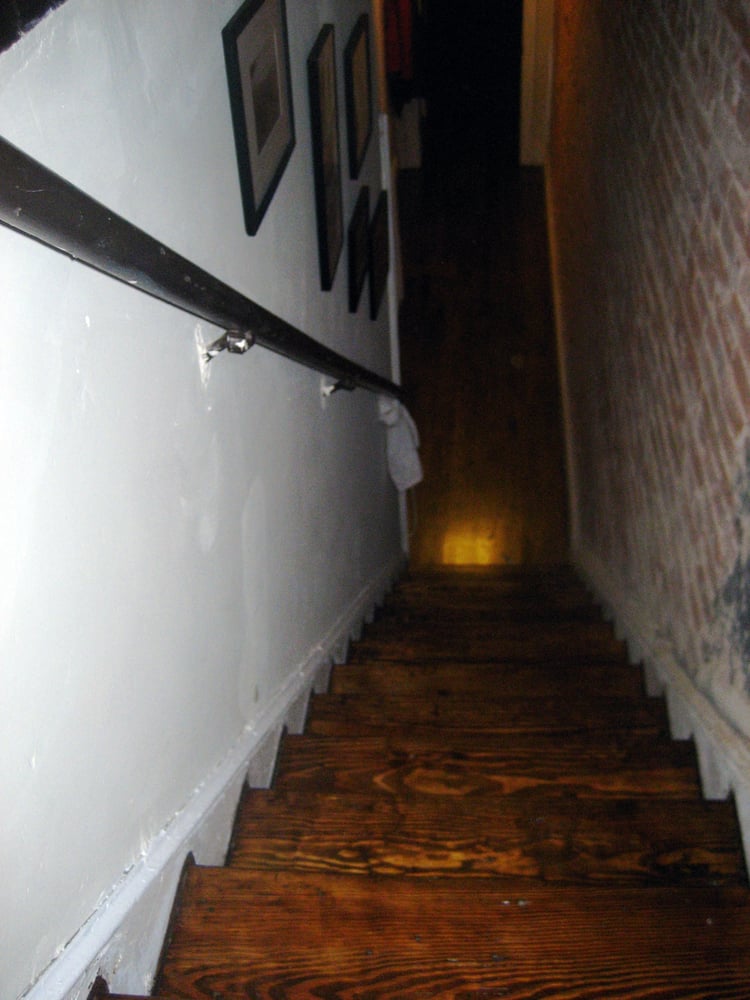Dark wooden staircase with handrail.