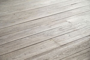 Here's an alt tag for the image: Grey wood floorboards.