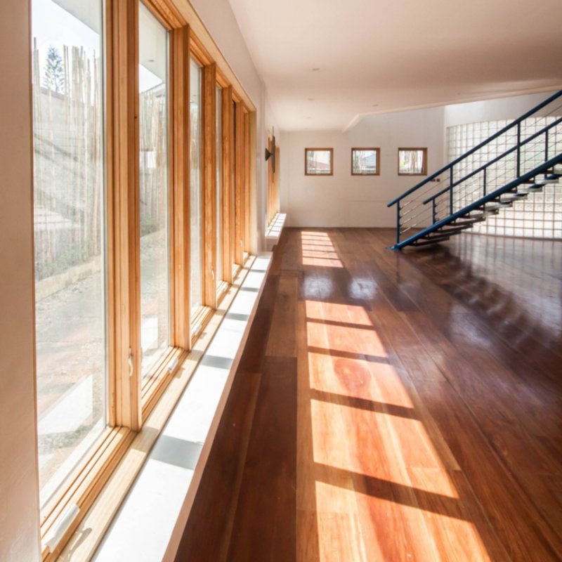 Sunny room with hardwood floors and large windows.