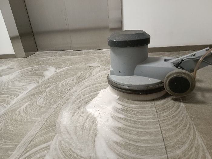 Floor buffer cleaning tiled floor.