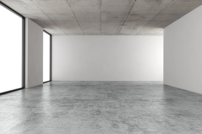 Empty room with concrete floor and windows.