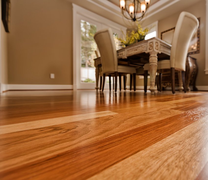 Hardwood floor showing effects of humidity in dining room interior by Elegant Floor Services